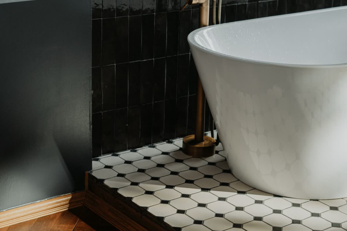A freestanding tub on a patterned tile floor