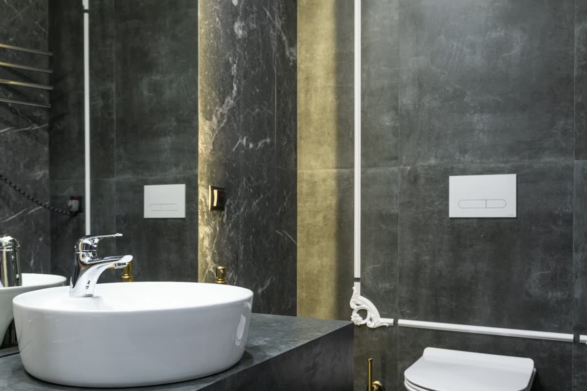 A stone bathroom with a round white basin